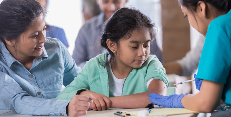 child getting a needle in her arm